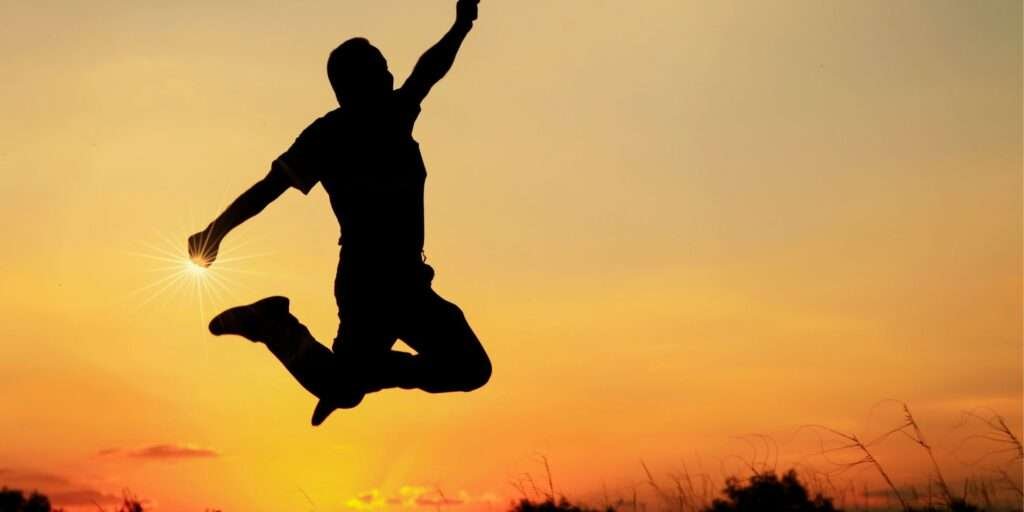 Health benefits of organic himalayan shilajit. A man jumping in air against a sun rise showing he is full of energy.